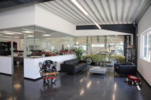 Vom Empfangsbereich aus fällt der Blick durch reichlich Glas auf die  Fahrzeugsammlung.