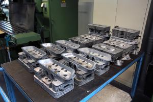 Eine ganze Gruppe von Porsche 356-Zylinderköpfen, vorbereitet zur mechanischen Bearbeitung.